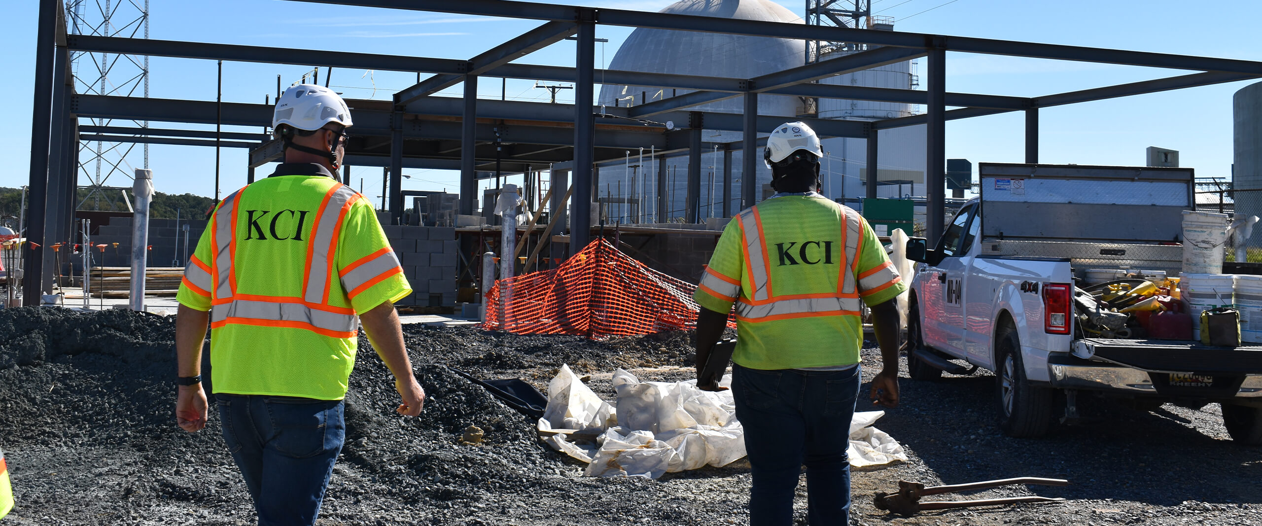 Two KCI employees supervise a job site