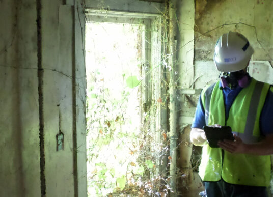 A KCI employee tests an old house for hazardous materials