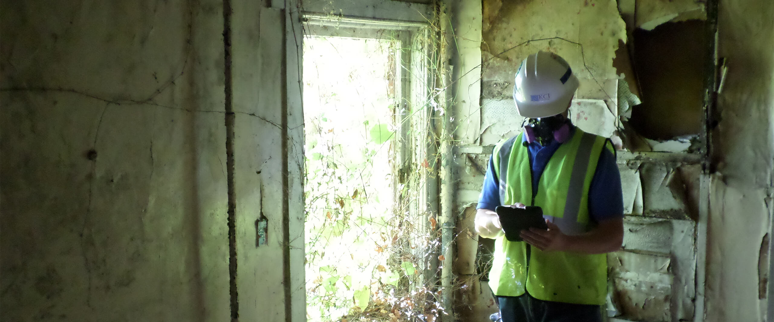 A KCI employee tests an old house for hazardous materials
