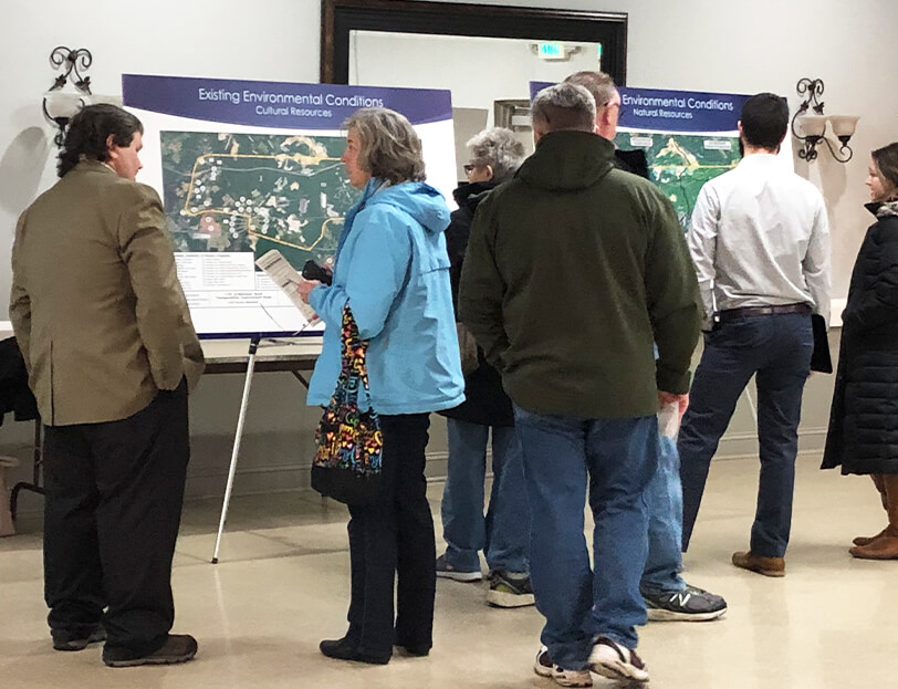 A group of people discussing transportation plans at a public outreach meeting