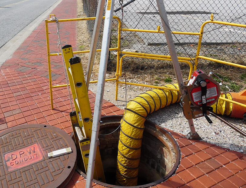 An open manhole with tools
