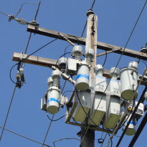 Close-up of insulators and transformers on a power distribution utility pole